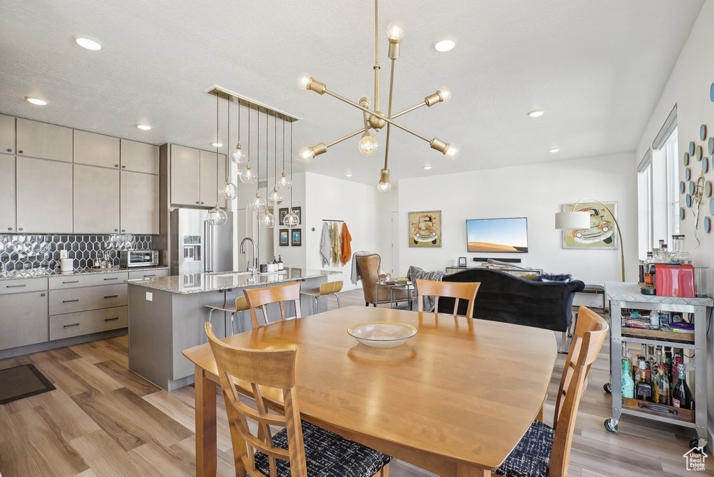 Dining room featuring a toaster, recessed lighting, light wood finished floors, and a chandelier