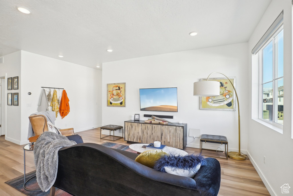 Living area featuring recessed lighting, light wood-style flooring, and baseboards