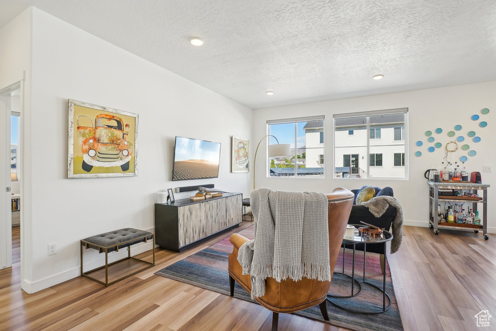 Dining room featuring baseboards, recessed lighting, a textured ceiling, and wood finished floors