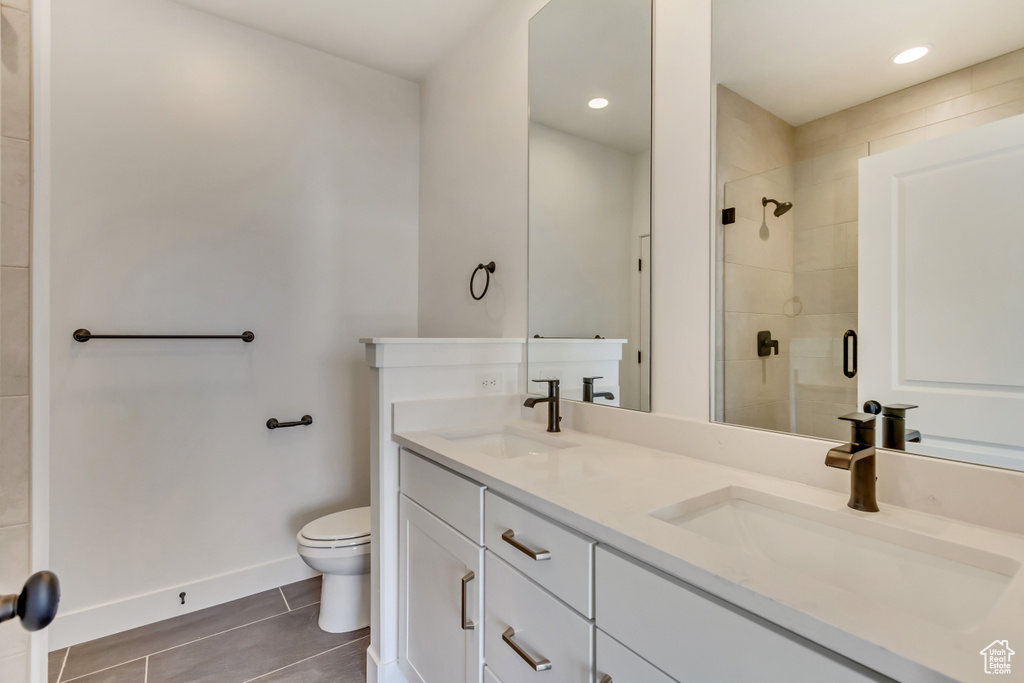 Bathroom featuring tile patterned flooring, a sink, a shower stall, and toilet