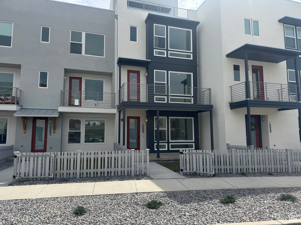 Multi unit property with stucco siding and a fenced front yard