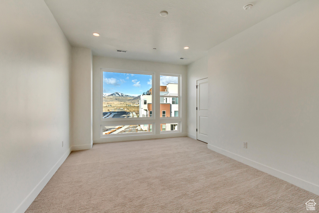 Spare room with visible vents, baseboards, recessed lighting, and light colored carpet