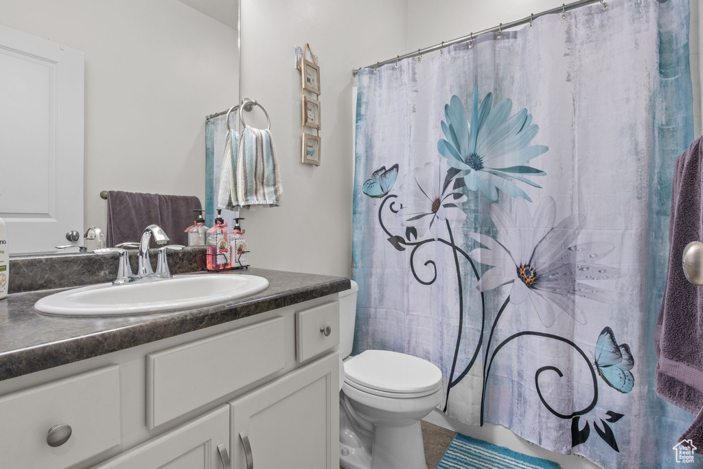 Full bathroom with a shower with curtain, vanity, and toilet
