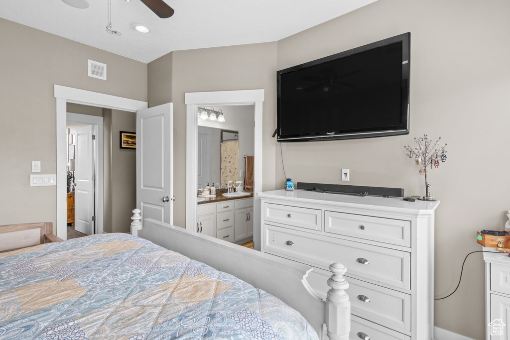 Bedroom with visible vents, a ceiling fan, a sink, and connected bathroom