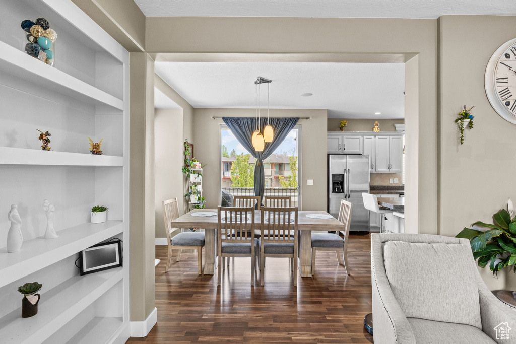 Dining area featuring built in shelves, baseboards, and dark wood-type flooring