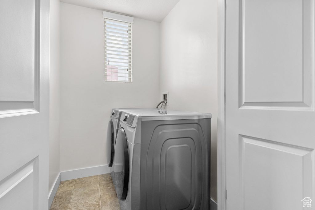 Laundry room with baseboards, laundry area, and separate washer and dryer