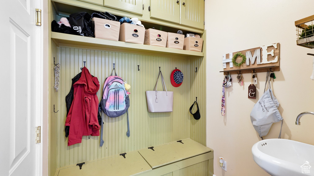 Mudroom featuring baseboards and a sink