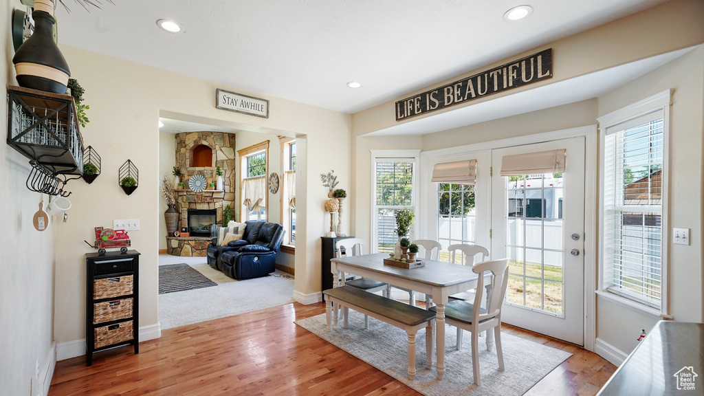 Dining space with recessed lighting, baseboards, wood finished floors, and a fireplace