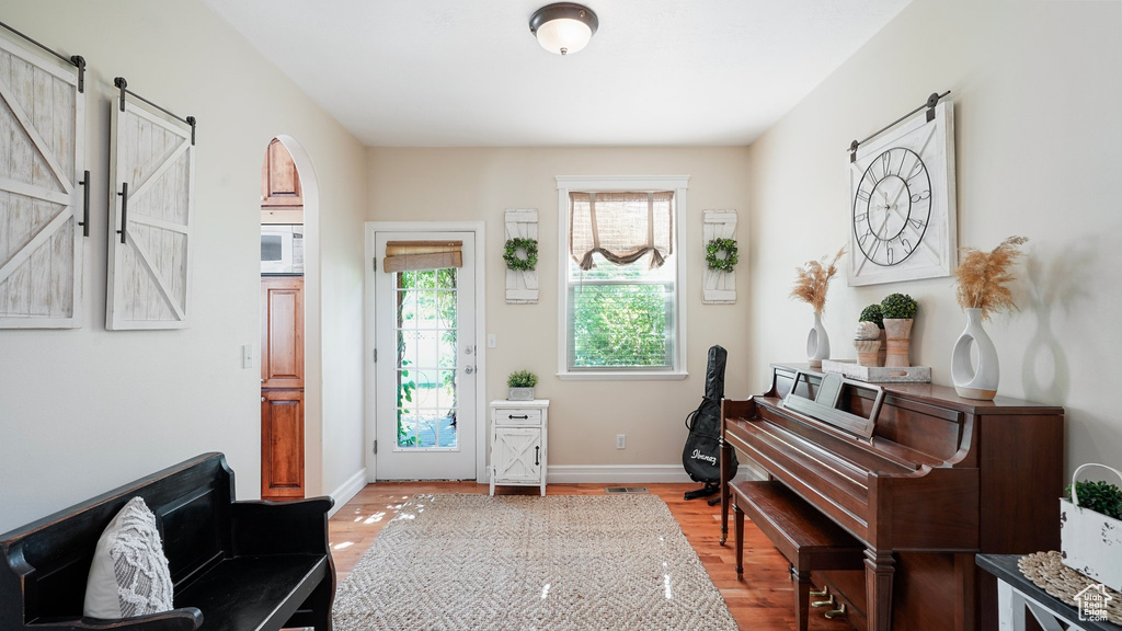 Foyer with baseboards, wood finished floors, and a barn door
