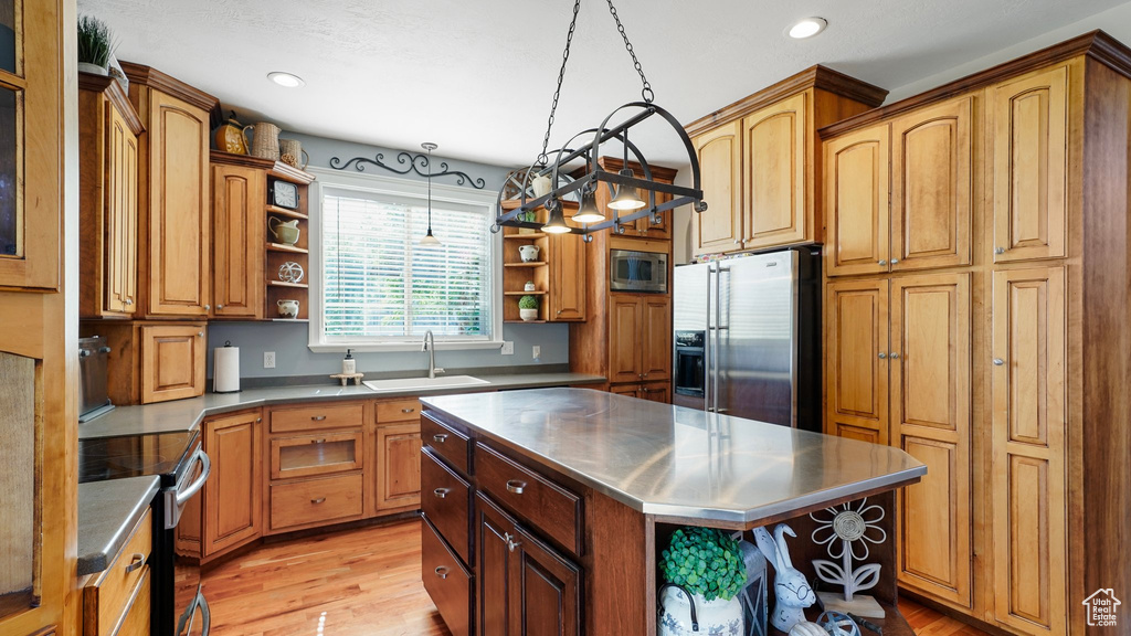 Kitchen featuring open shelves, a sink, light wood-style flooring, stainless steel counters, and appliances with stainless steel finishes
