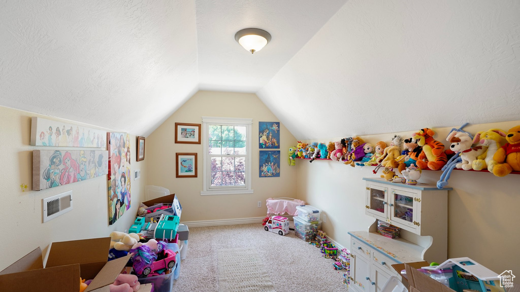 Playroom featuring carpet, visible vents, lofted ceiling, and baseboards