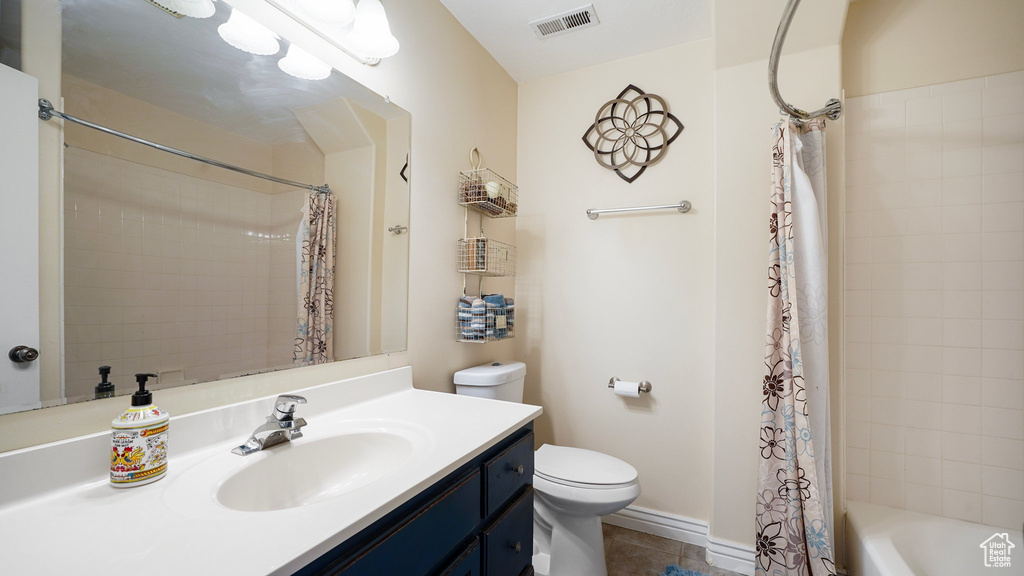 Bathroom with tile patterned floors, visible vents, toilet, vanity, and shower / tub combo with curtain