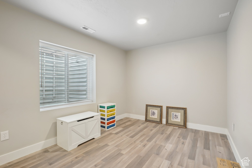 Interior space with light wood finished floors, visible vents, and baseboards
