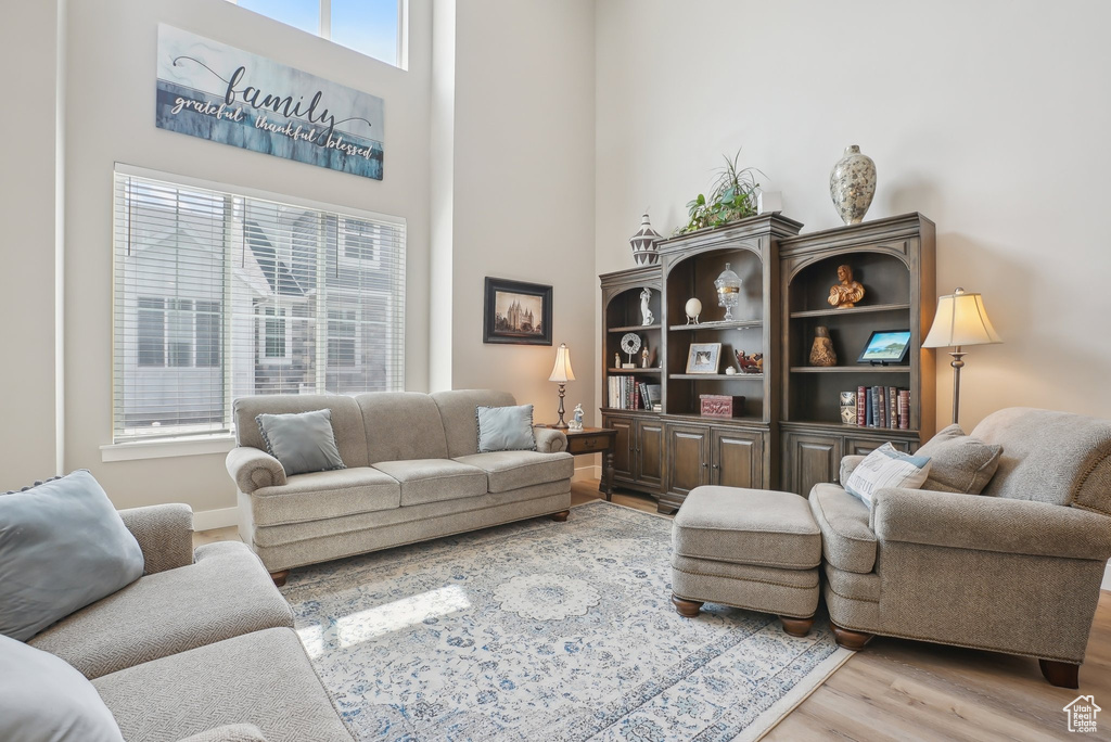 Living room featuring a towering ceiling and wood finished floors