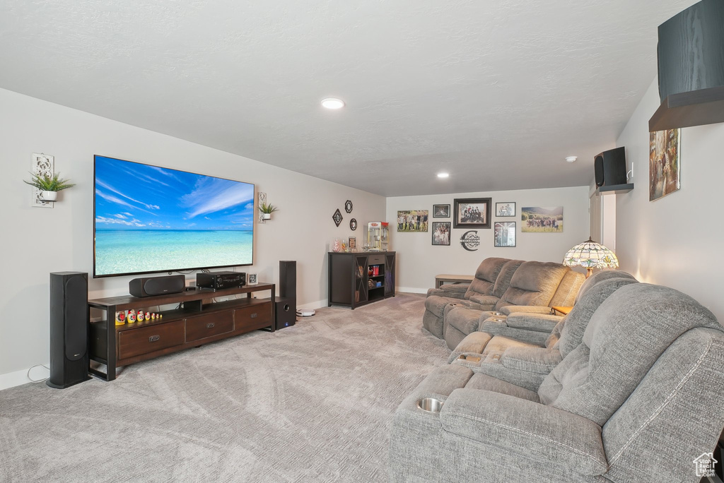 Carpeted living area with recessed lighting and baseboards