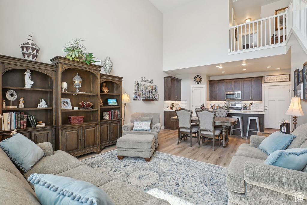 Living room with light wood-style flooring and a high ceiling
