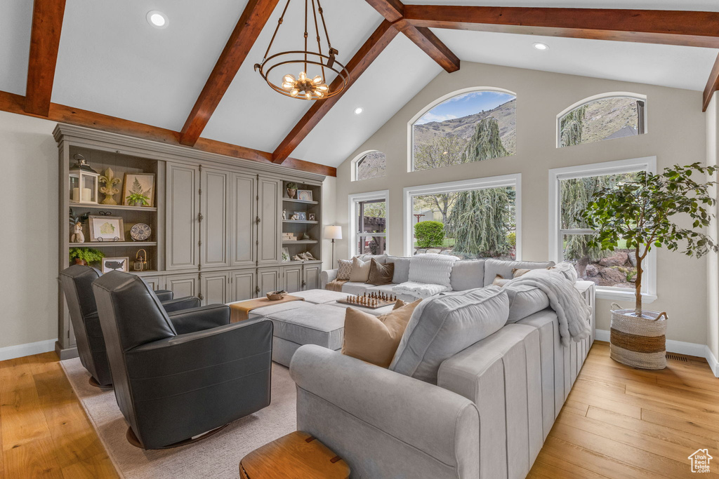 Living area featuring beamed ceiling, light wood-style floors, and baseboards