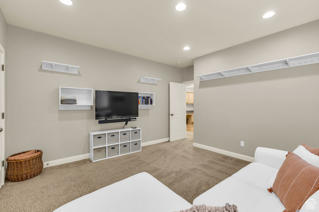 Carpeted living area with baseboards and recessed lighting