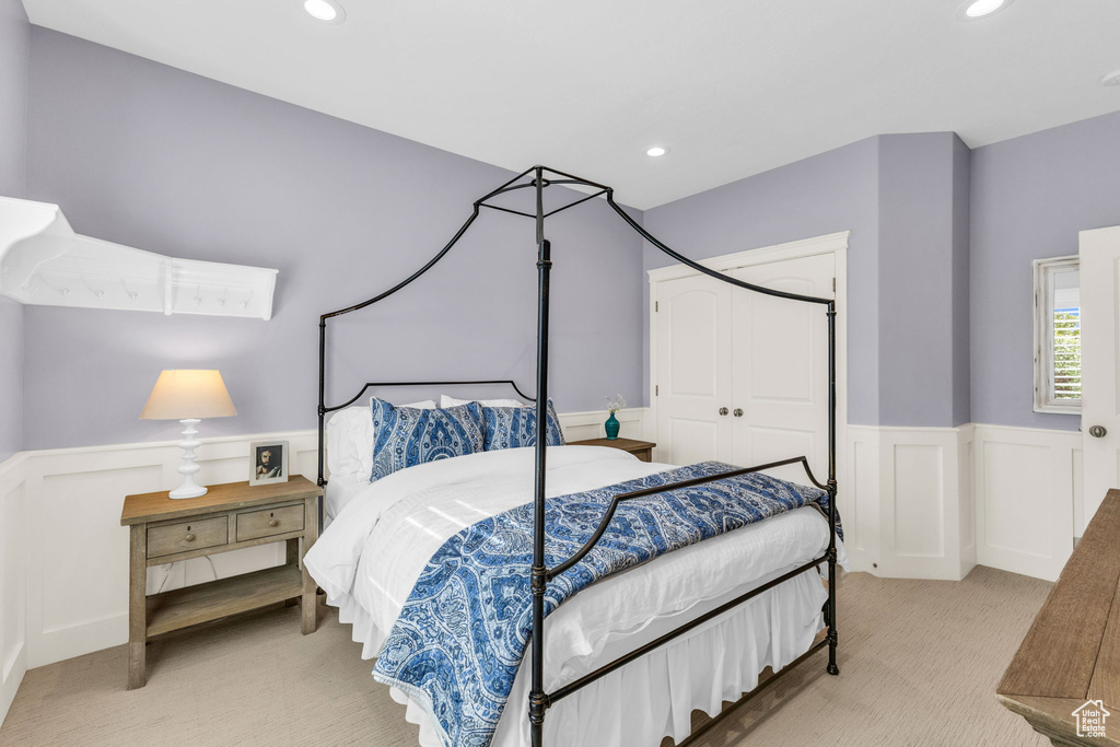 Carpeted bedroom featuring a wainscoted wall, recessed lighting, a closet, and a decorative wall