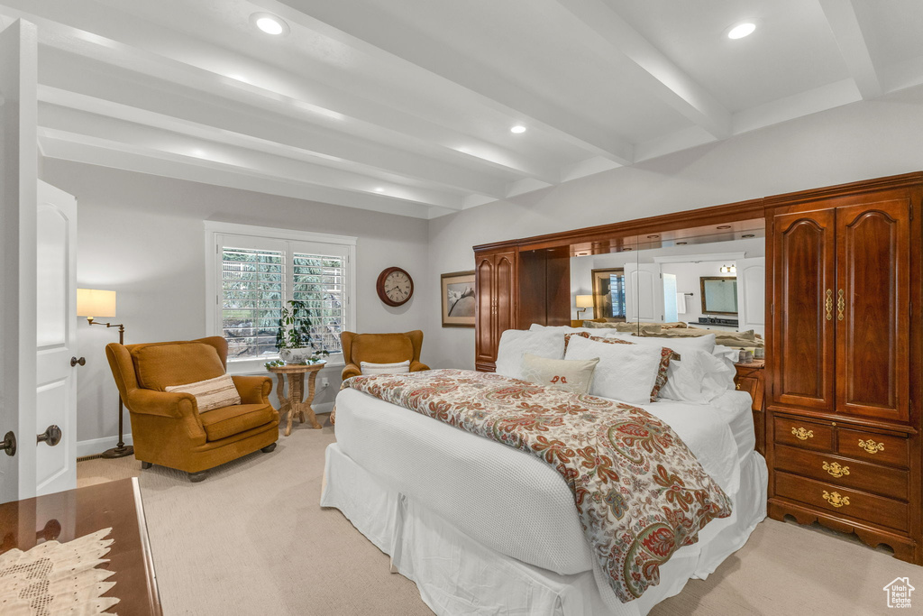 Bedroom with light carpet, beamed ceiling, and recessed lighting