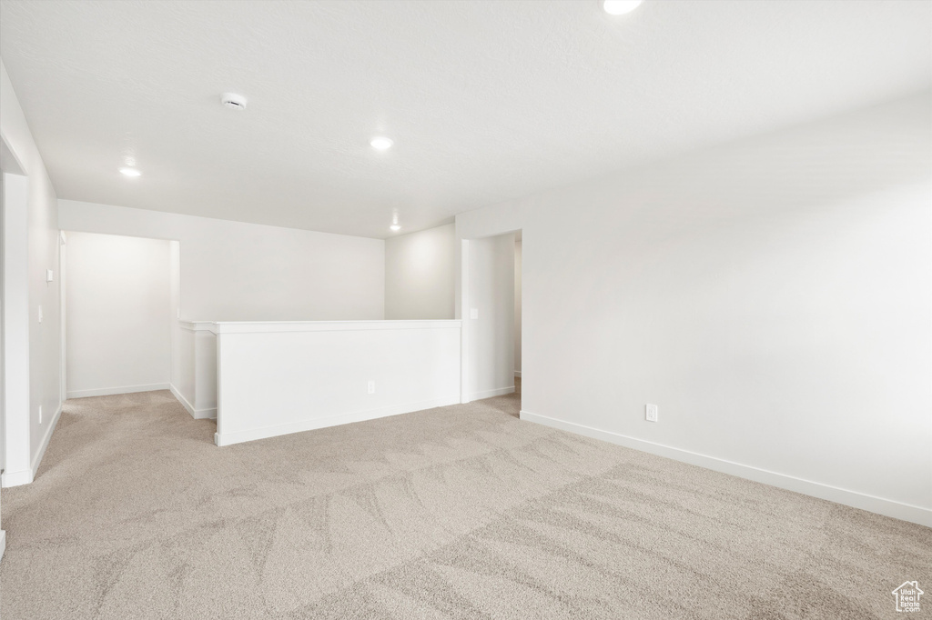 Empty room featuring light colored carpet, recessed lighting, and a smoke detector