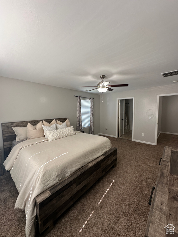 Carpeted bedroom featuring baseboards, visible vents, a spacious closet, and ceiling fan