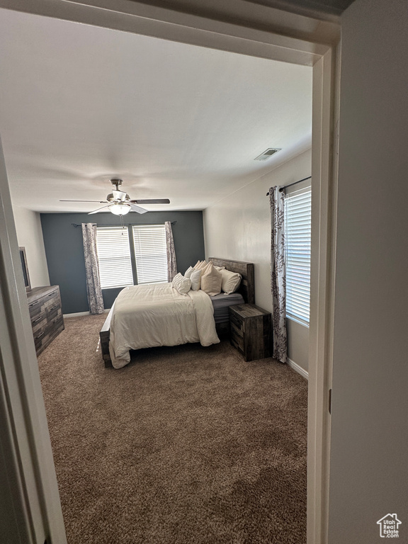 Bedroom featuring carpet, visible vents, and multiple windows