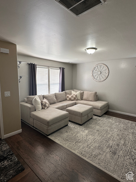 Living area with hardwood / wood-style flooring, baseboards, and visible vents