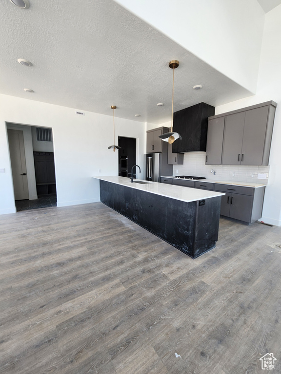 Kitchen with gray cabinetry, wood finished floors, light countertops, and a textured ceiling