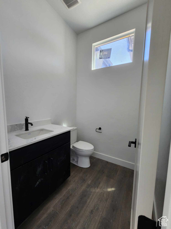 Half bath with vanity and wood finished floors