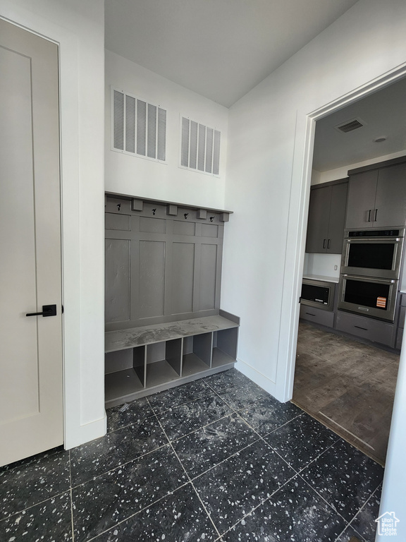 Mudroom with baseboards and dark tile patterned flooring