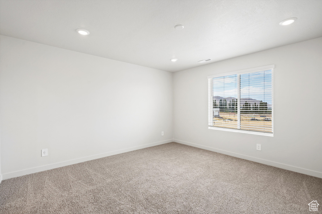 Carpeted empty room with recessed lighting