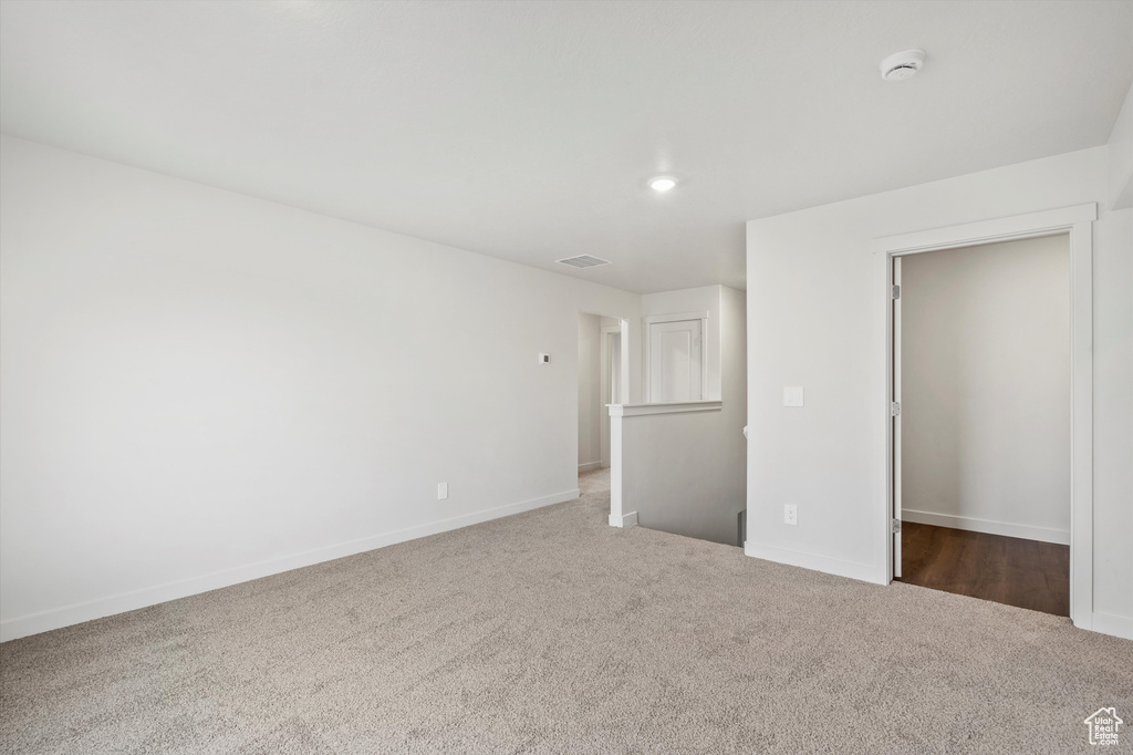 Unfurnished bedroom with carpet flooring, a walk in closet, and recessed lighting
