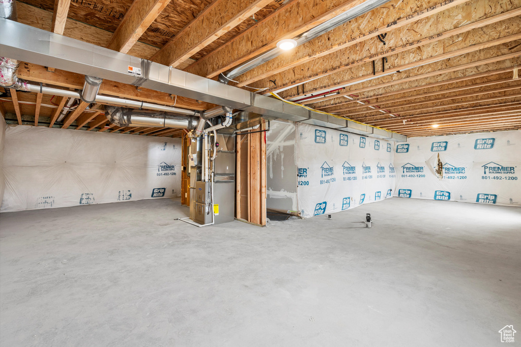 Unfinished below grade area featuring heating unit