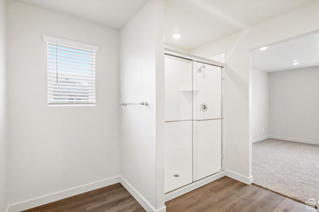 Full bathroom featuring a shower stall, wood finished floors, and recessed lighting