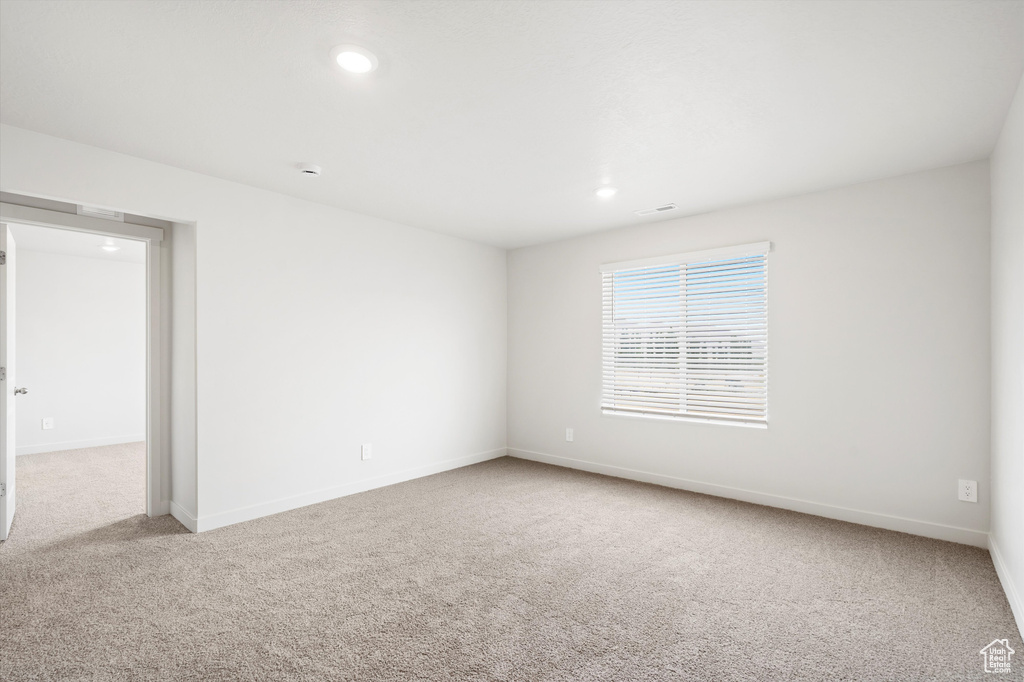 Carpeted spare room with recessed lighting and baseboards