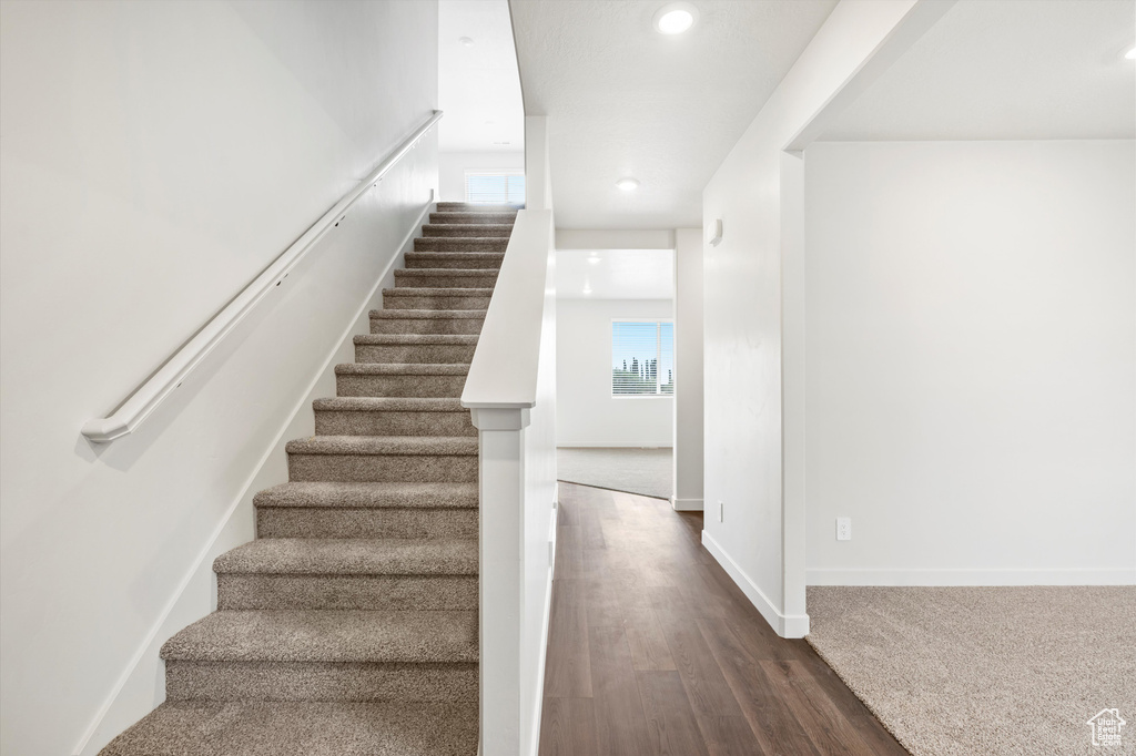 Stairway with recessed lighting and wood finished floors