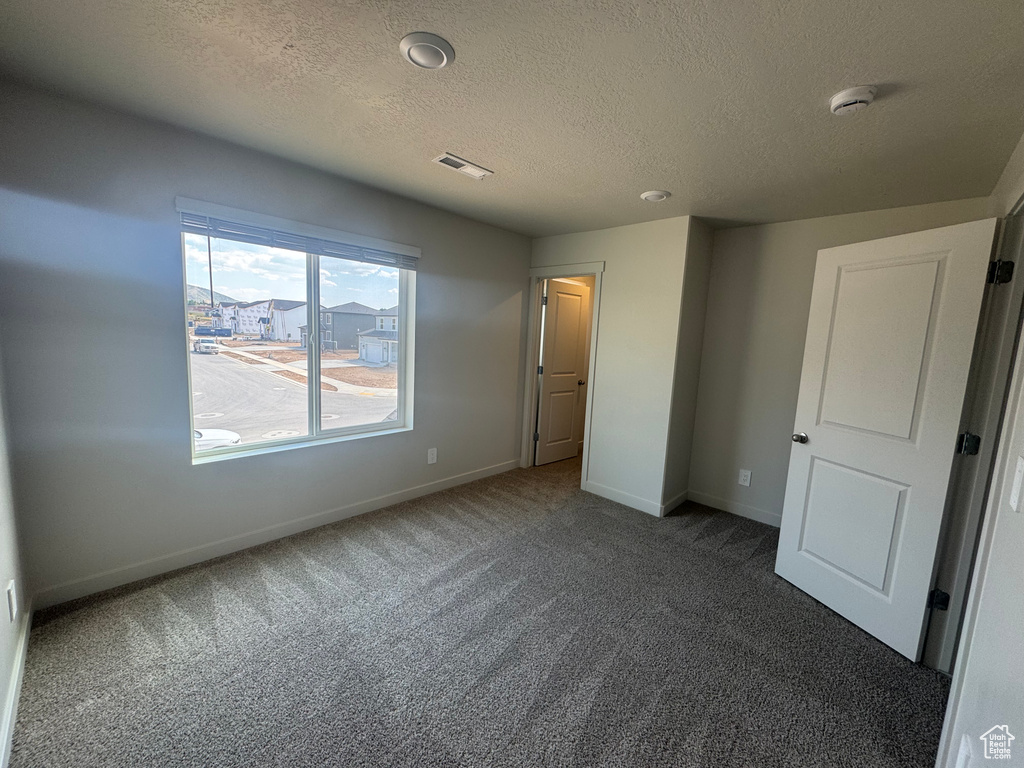 Unfurnished bedroom featuring carpet flooring and a textured ceiling