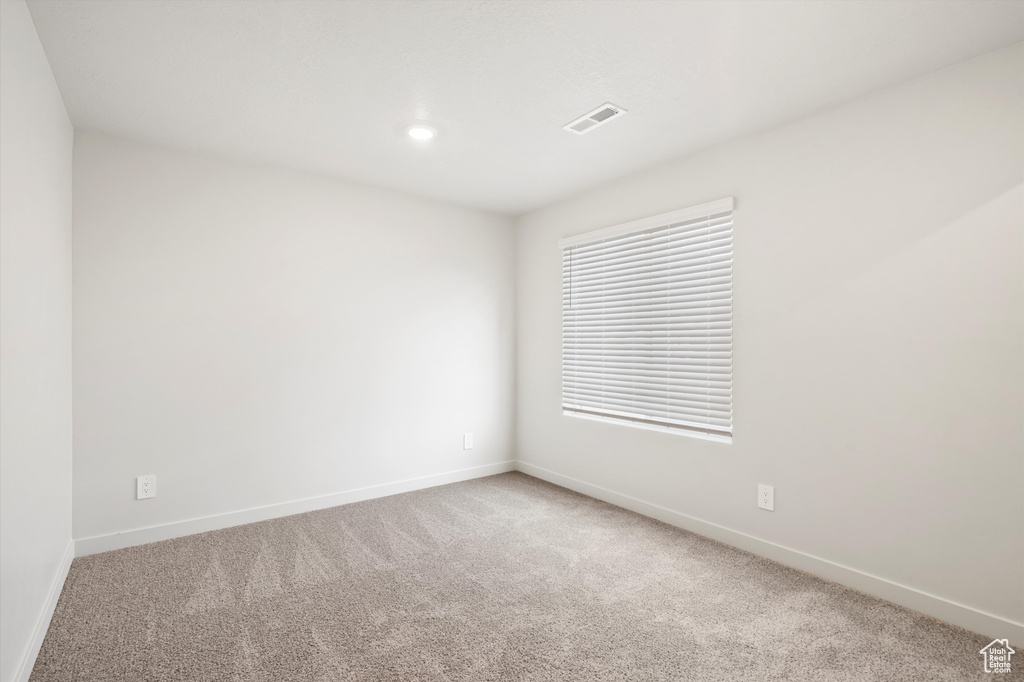 Carpeted empty room featuring baseboards
