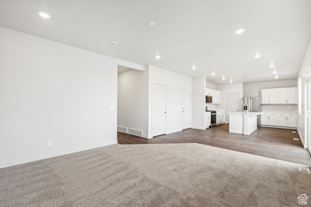 Unfurnished living room featuring dark carpet and recessed lighting