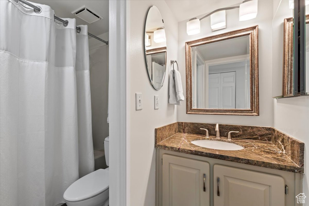 Full bathroom with visible vents, vanity, a shower with shower curtain, and toilet