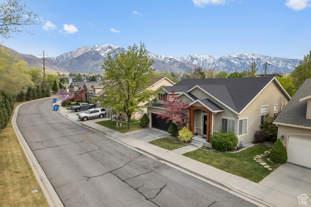 Exterior space with driveway, a mountain view, and stucco siding