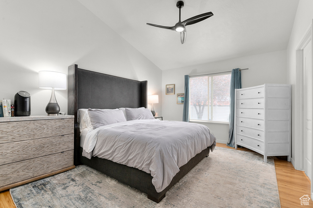 Bedroom with light wood-type flooring, vaulted ceiling, and a ceiling fan