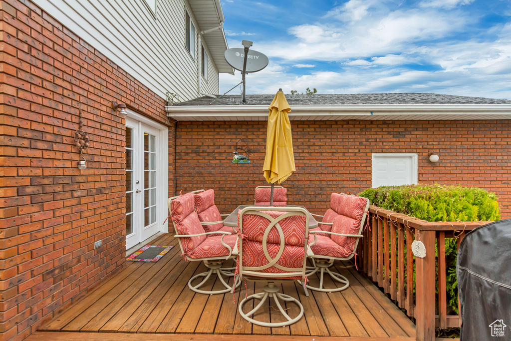 Deck with outdoor dining area, area for grilling, and french doors