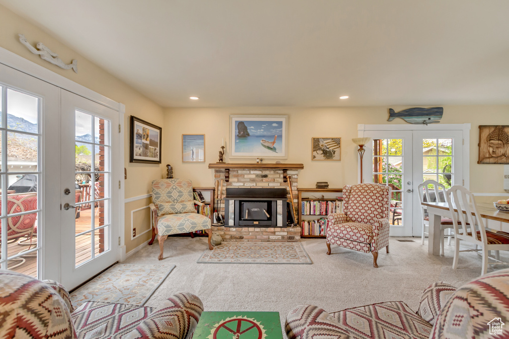 Carpeted living area with a fireplace, wainscoting, recessed lighting, and french doors