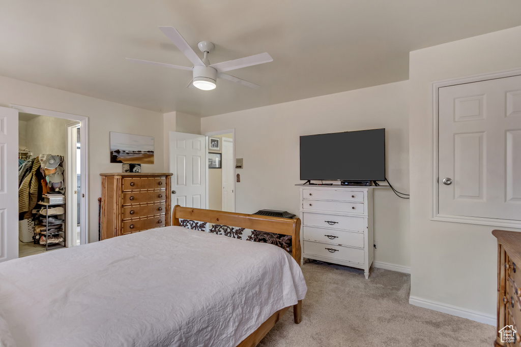 Bedroom with baseboards, light colored carpet, and ceiling fan