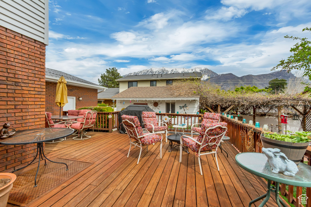 Wooden terrace featuring outdoor dining area, a mountain view, and an outdoor hangout area