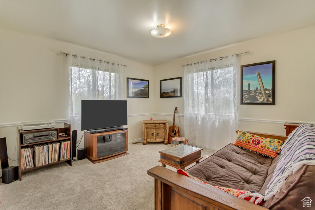Living room with carpet flooring and a healthy amount of sunlight
