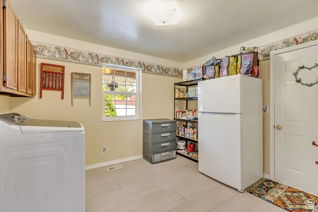 Washroom featuring washer / dryer, baseboards, visible vents, and cabinet space
