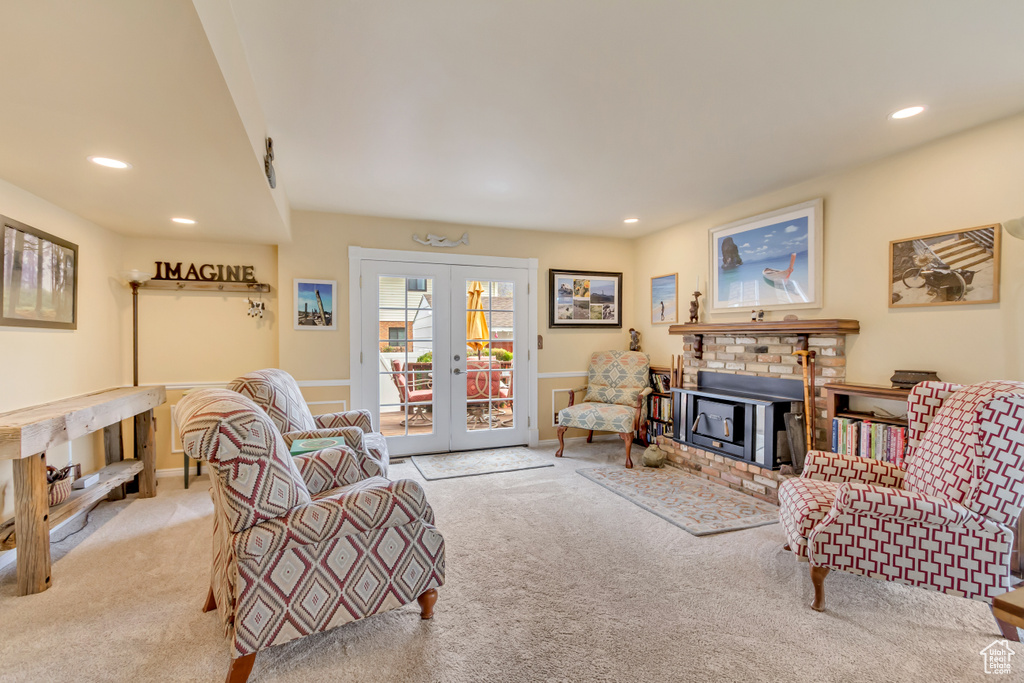 Living room featuring french doors, carpet flooring, recessed lighting, and a brick fireplace